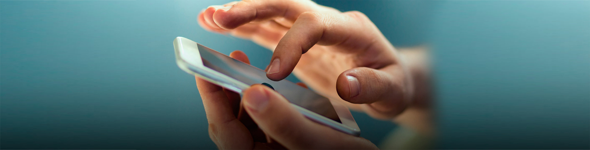 Imagem de uma mão segurando um smartfone e com a outra mão tocando na tela
