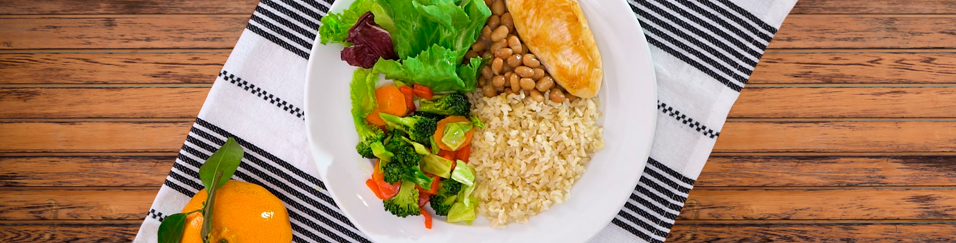 Prato com arroz, feijão, uma carne e uma salada com diversas verduras